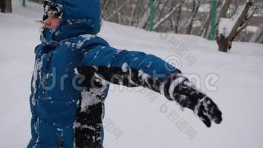 一个孩子在雪地里慢慢地摔倒。 暴风雪